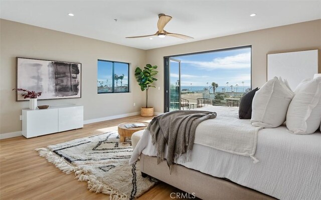 bedroom featuring access to exterior, baseboards, and wood finished floors