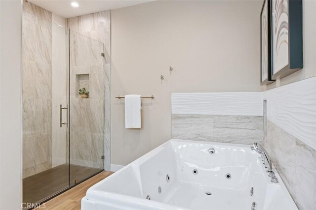 full bathroom with a whirlpool tub, wood finished floors, and a shower stall