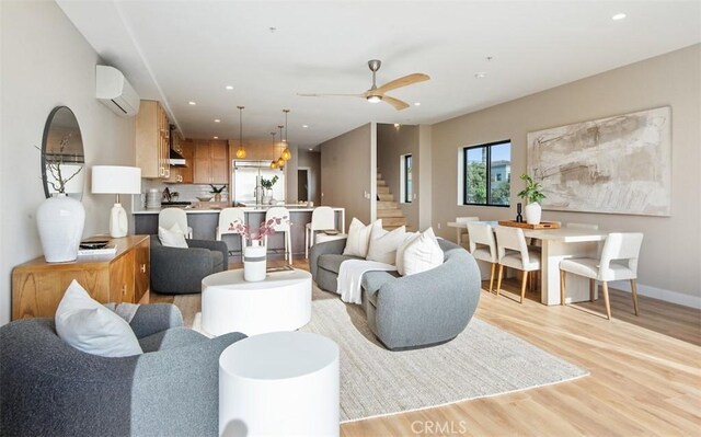 living room with light wood-type flooring, stairway, recessed lighting, and a wall mounted AC