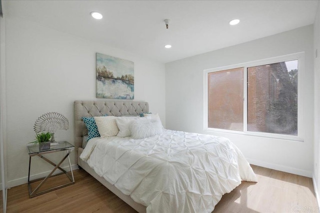 bedroom with recessed lighting, baseboards, and wood finished floors