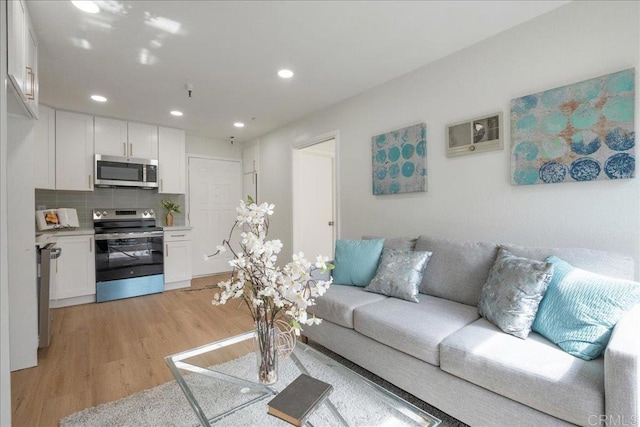 living area featuring light wood-style flooring and recessed lighting