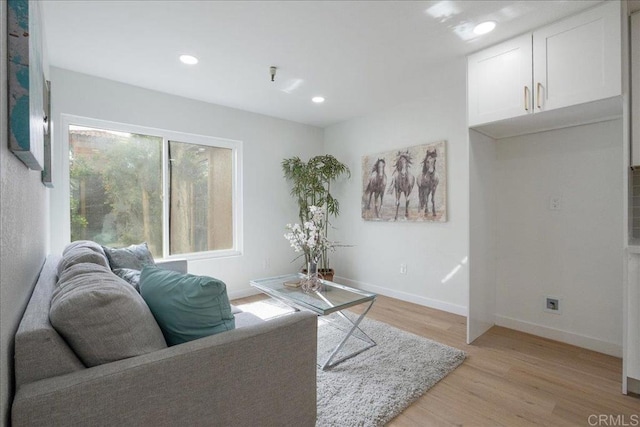 living area featuring light wood-style floors, baseboards, and recessed lighting