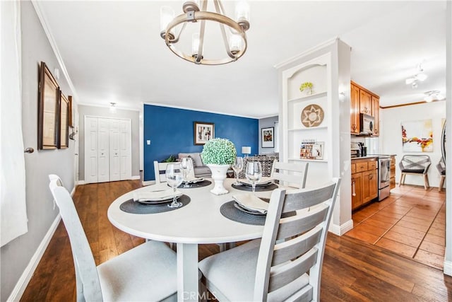 dining room featuring dark wood-style floors, ornamental molding, baseboards, and an inviting chandelier