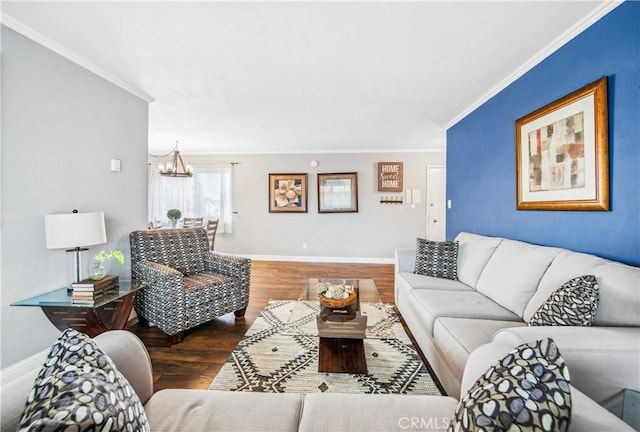 living area featuring ornamental molding, an inviting chandelier, baseboards, and wood finished floors