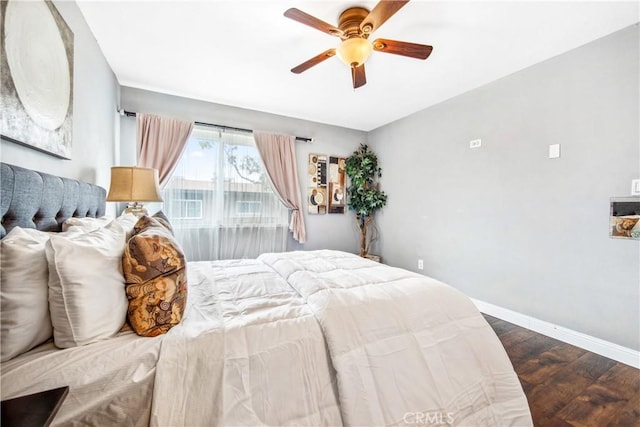 bedroom with ceiling fan, wood finished floors, and baseboards