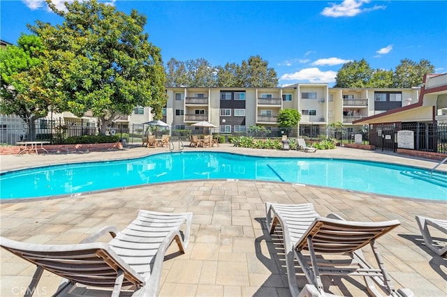 pool with a patio area and fence