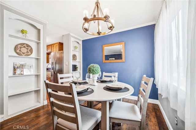 dining room featuring crown molding, dark wood finished floors, baseboards, and an inviting chandelier