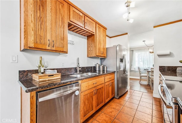 kitchen featuring light tile patterned floors, appliances with stainless steel finishes, brown cabinetry, ornamental molding, and a sink