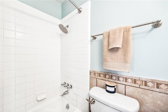 full bathroom with toilet, wainscoting, tile walls, and bathing tub / shower combination