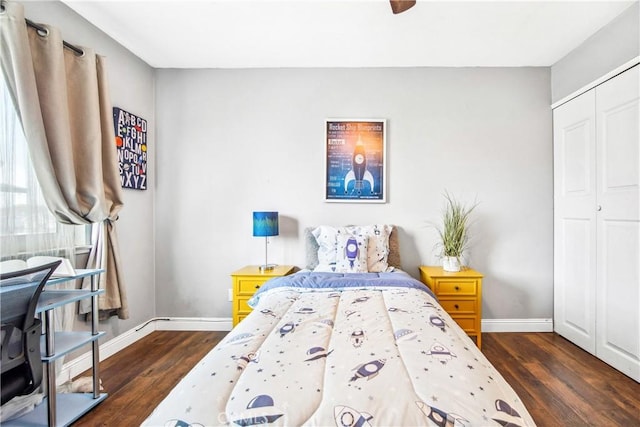 bedroom featuring dark wood-style floors, a closet, a ceiling fan, and baseboards