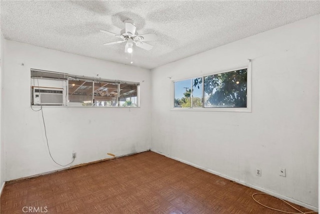 unfurnished room featuring cooling unit, baseboards, a textured ceiling, and a ceiling fan