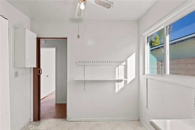 spare room with baseboards and a ceiling fan