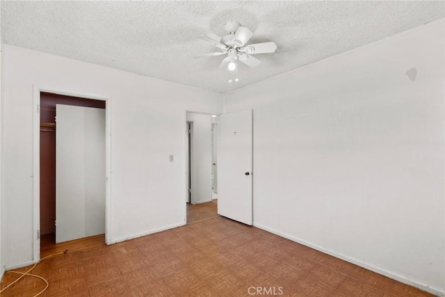 unfurnished bedroom with a closet, baseboards, a textured ceiling, and a ceiling fan