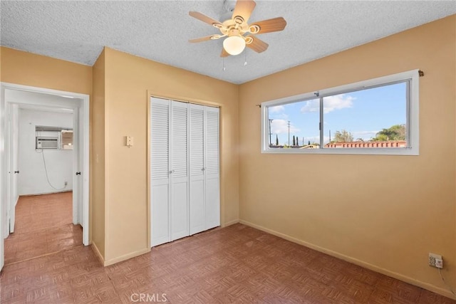 unfurnished bedroom featuring a closet, a textured ceiling, baseboards, and a ceiling fan