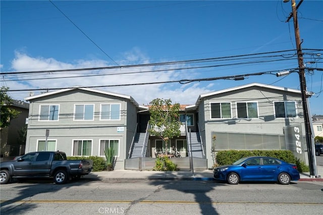 view of front of house featuring stairway and stucco siding