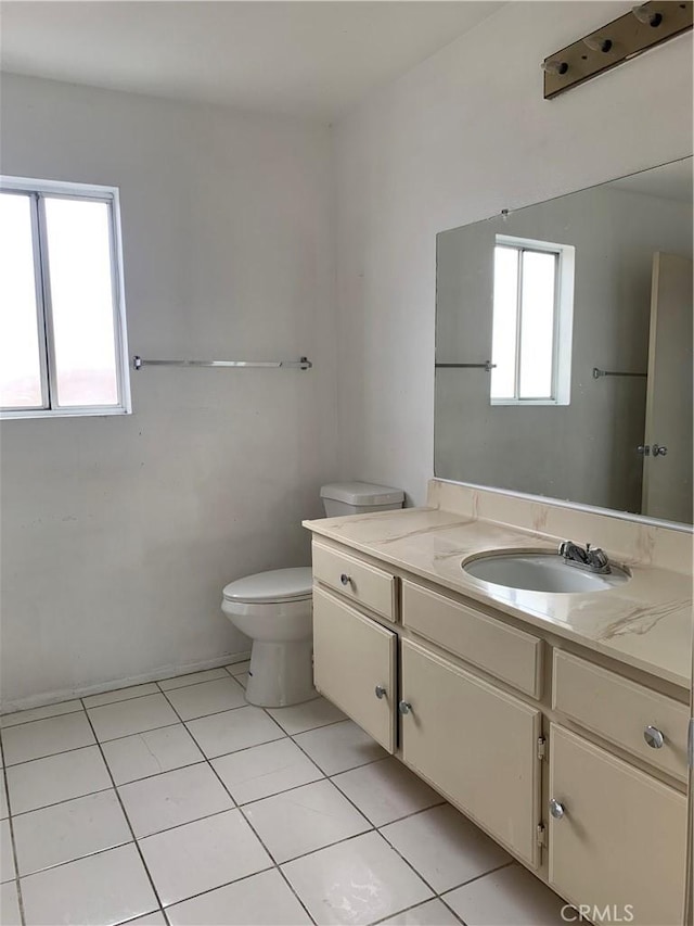 half bathroom featuring toilet, tile patterned floors, and vanity