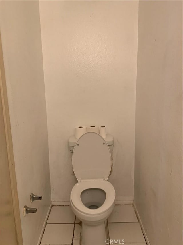 bathroom featuring baseboards, toilet, and tile patterned floors