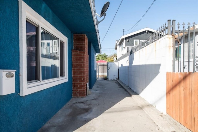 view of side of home featuring fence and stucco siding