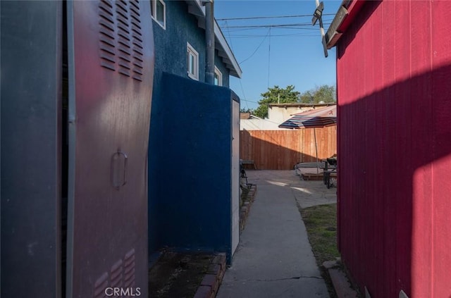 view of side of home featuring an outdoor structure and fence