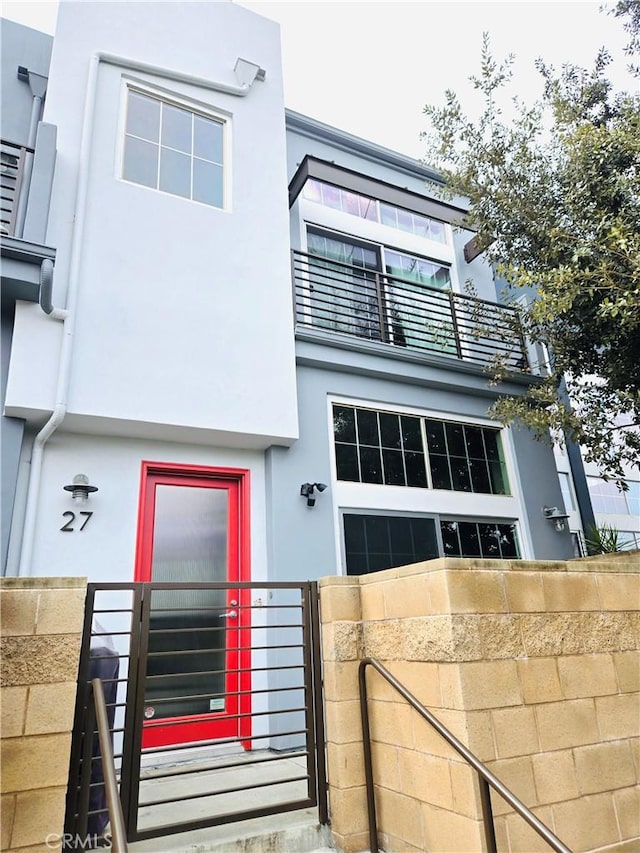 view of front of house featuring fence and stucco siding