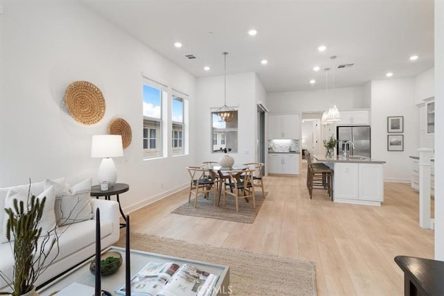 living room featuring visible vents, recessed lighting, light wood-type flooring, and baseboards