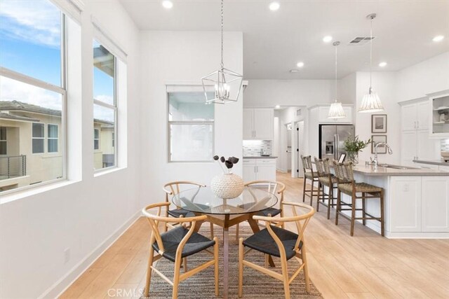 dining room with visible vents, baseboards, light wood-style flooring, recessed lighting, and a notable chandelier