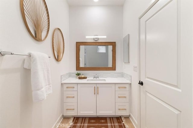 bathroom featuring vanity, wood finished floors, and baseboards