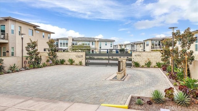 surrounding community with a gate, fence, and a residential view