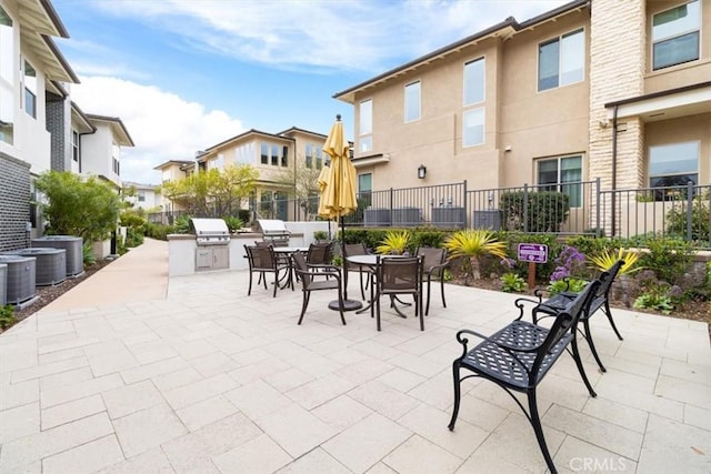 view of patio with area for grilling, central air condition unit, grilling area, and fence