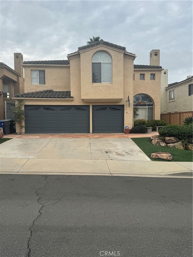 view of front of house featuring concrete driveway, an attached garage, and stucco siding