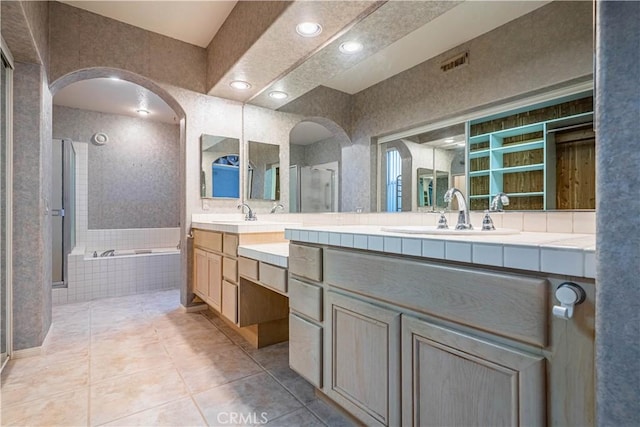 bathroom with a sink, a bath, tile patterned floors, and a shower stall