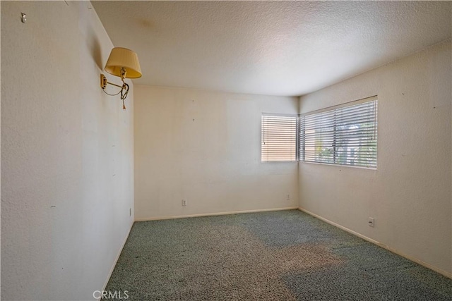 empty room featuring baseboards, carpet flooring, and a textured ceiling