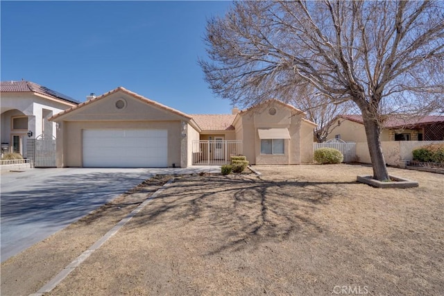 view of front of property featuring stucco siding, concrete driveway, a gate, fence, and a garage