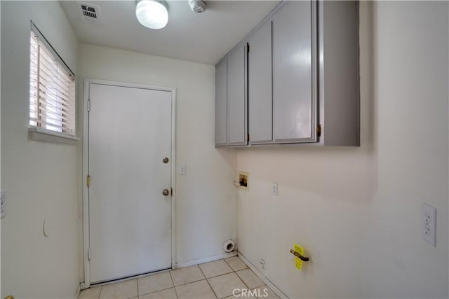 laundry area with cabinet space, visible vents, and light tile patterned flooring