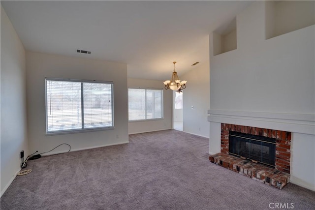 unfurnished living room featuring a fireplace, visible vents, a chandelier, and carpet flooring