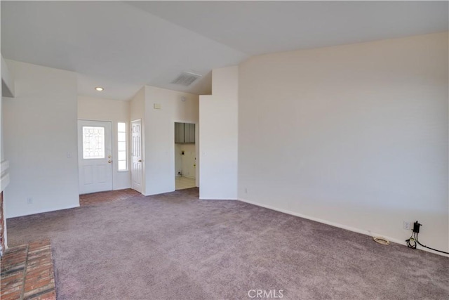 interior space featuring lofted ceiling, carpet, and visible vents