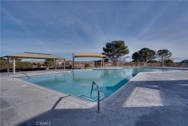 community pool featuring fence, a gazebo, and a patio