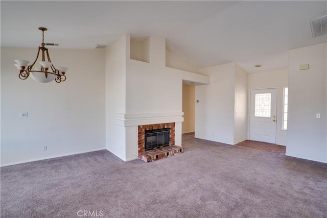 unfurnished living room with a brick fireplace, carpet flooring, a notable chandelier, and visible vents