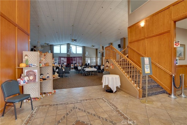 interior space with lofted ceiling, wood walls, wood ceiling, stairway, and tile patterned floors