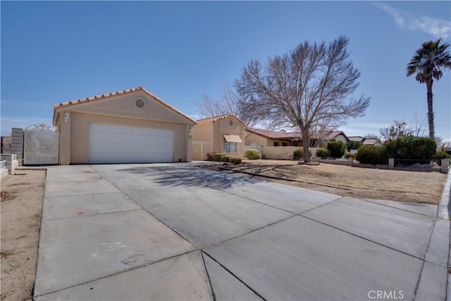 mediterranean / spanish house featuring driveway, a gate, fence, and stucco siding