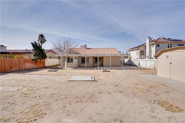 rear view of property with a patio, a storage unit, an outdoor structure, and a fenced backyard