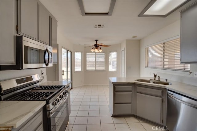 kitchen featuring appliances with stainless steel finishes, visible vents, a sink, and gray cabinetry