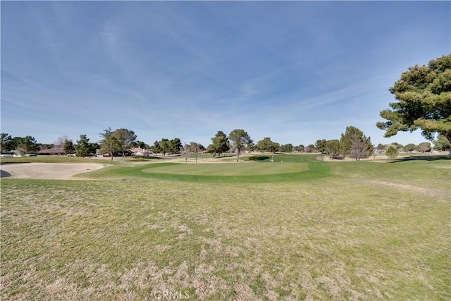 view of property's community featuring golf course view and a lawn