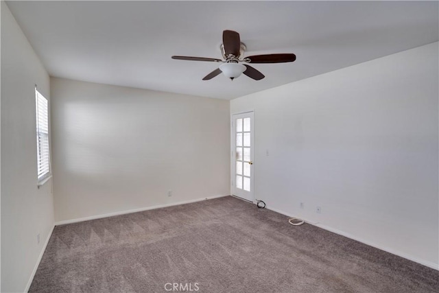 spare room featuring ceiling fan, carpet flooring, and baseboards