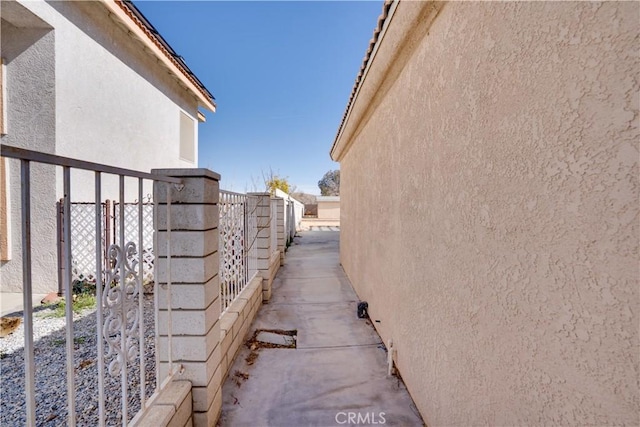 view of side of home with fence and stucco siding