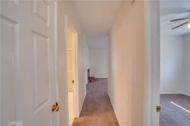 corridor with baseboards and carpet flooring