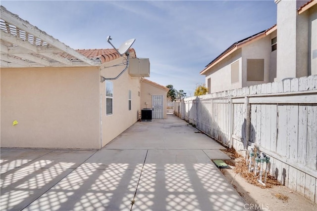 view of patio / terrace with central AC unit and fence