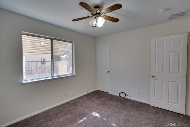 empty room featuring carpet, visible vents, ceiling fan, and baseboards