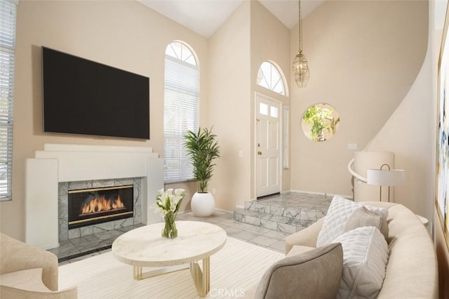 living room with high vaulted ceiling, a high end fireplace, baseboards, and tile patterned floors