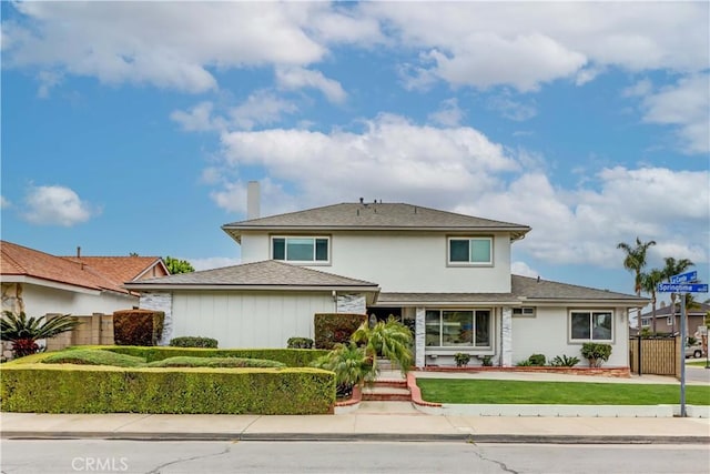 view of front of home featuring driveway, a front lawn, and fence